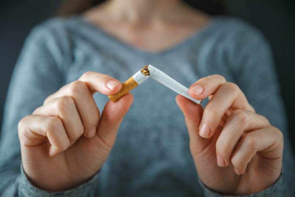 Woman breaks cigarette in half