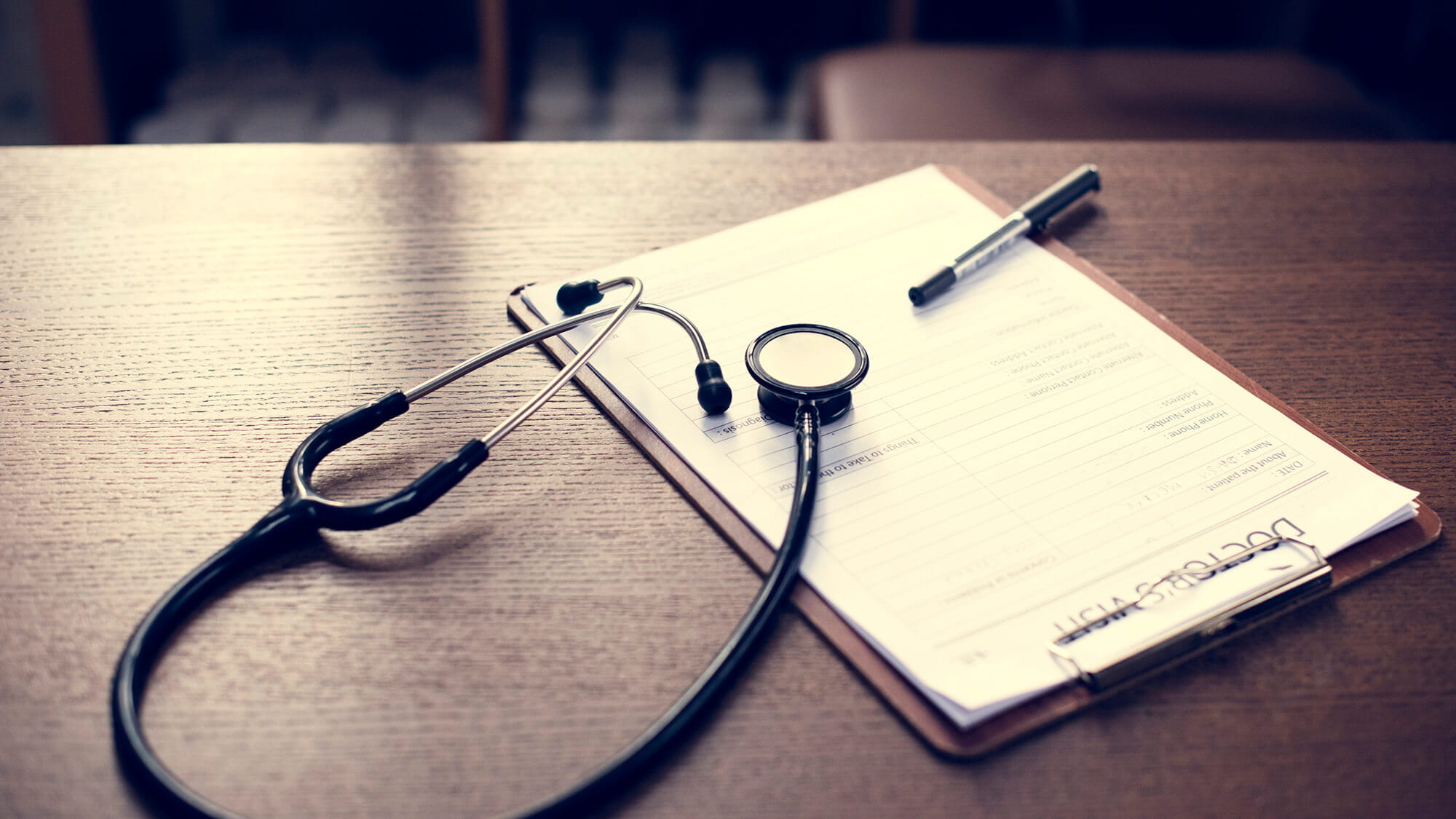 checkup form and stethoscope laying on desk