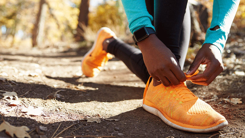 Female African American runner tying sneaker