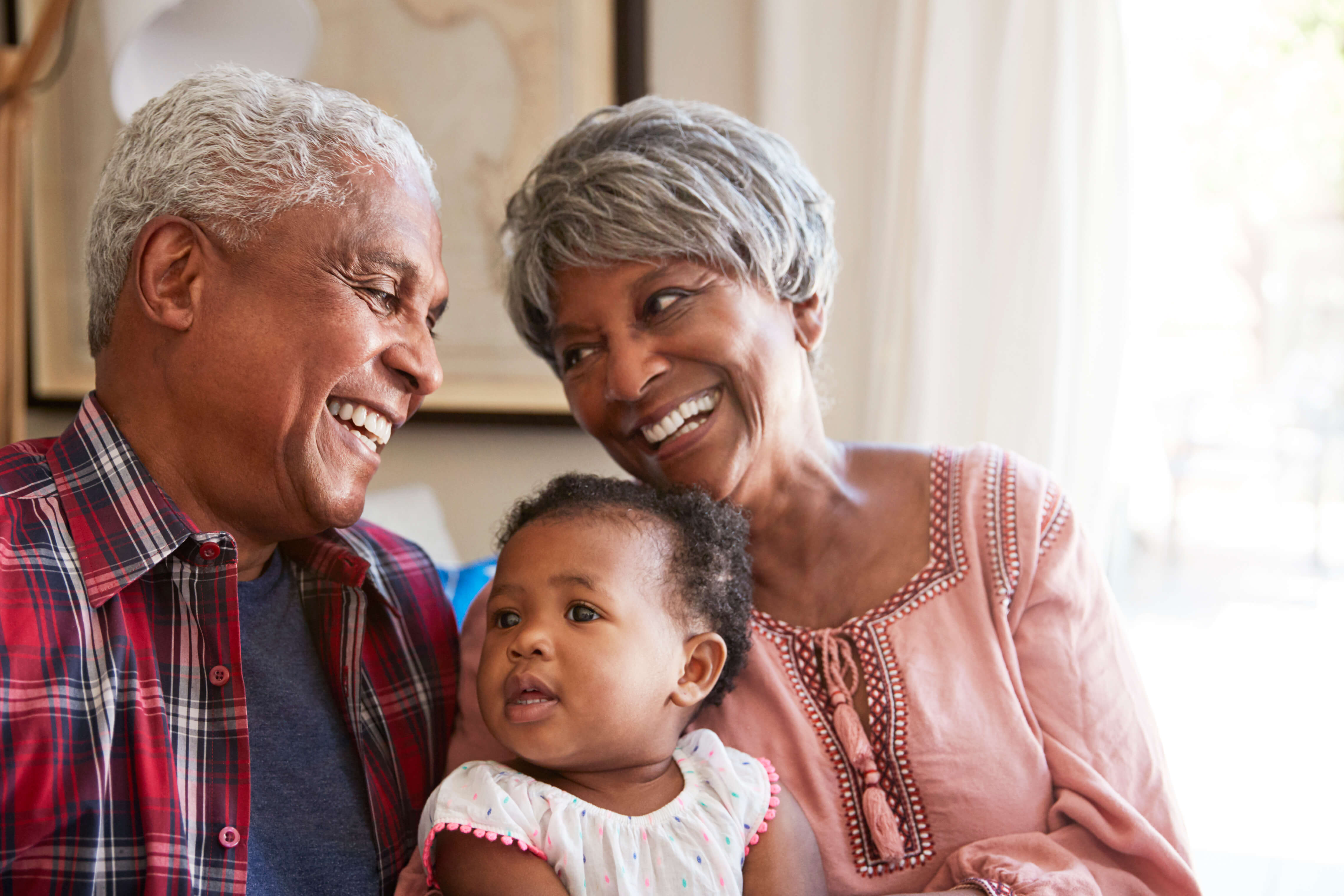 Grandparents sitting on couch with grandchild