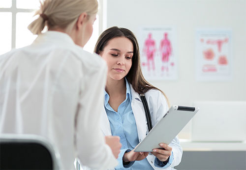 two female doctors looking at clipboard