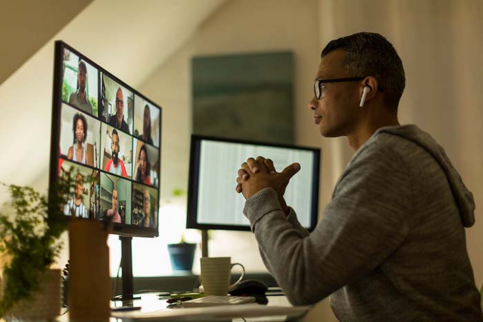 Man at home on video call with coworkers