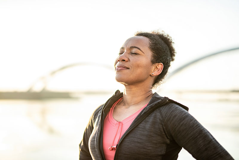 woman listening outdoors with eyes closed